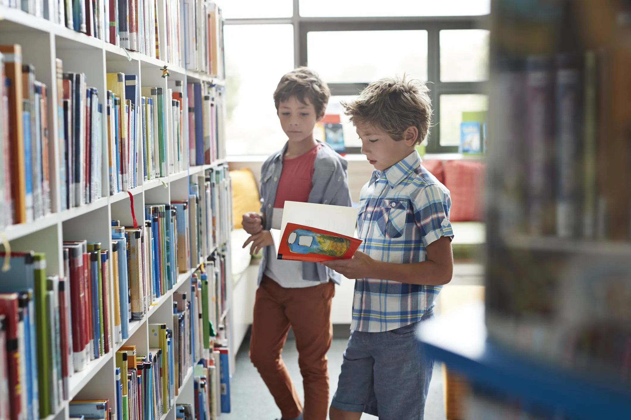 Boys reading books in library 