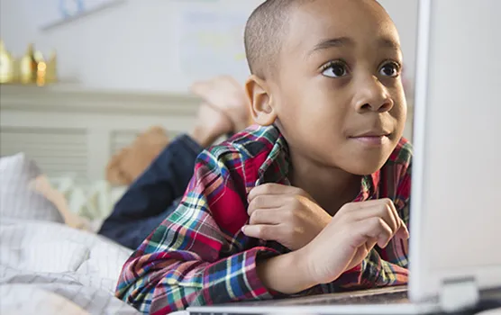 kid using laptop in their bedroom
