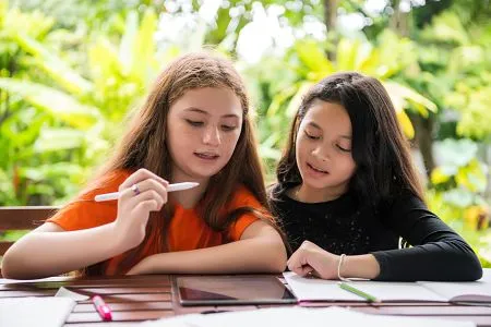 Two students doing homework on a tablet