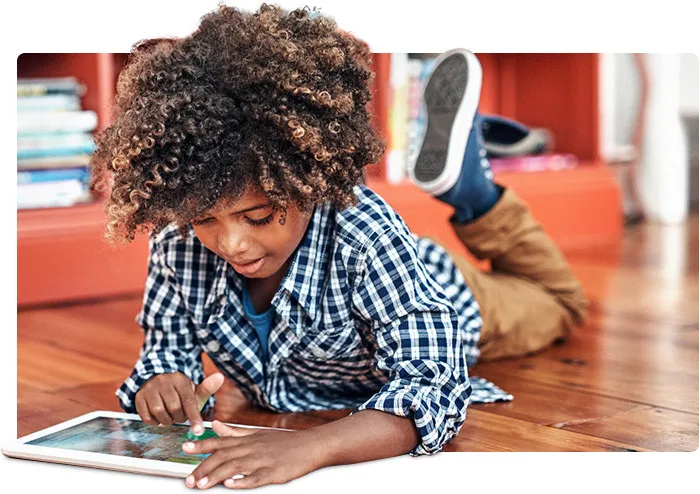 Young boy reading on a laptop