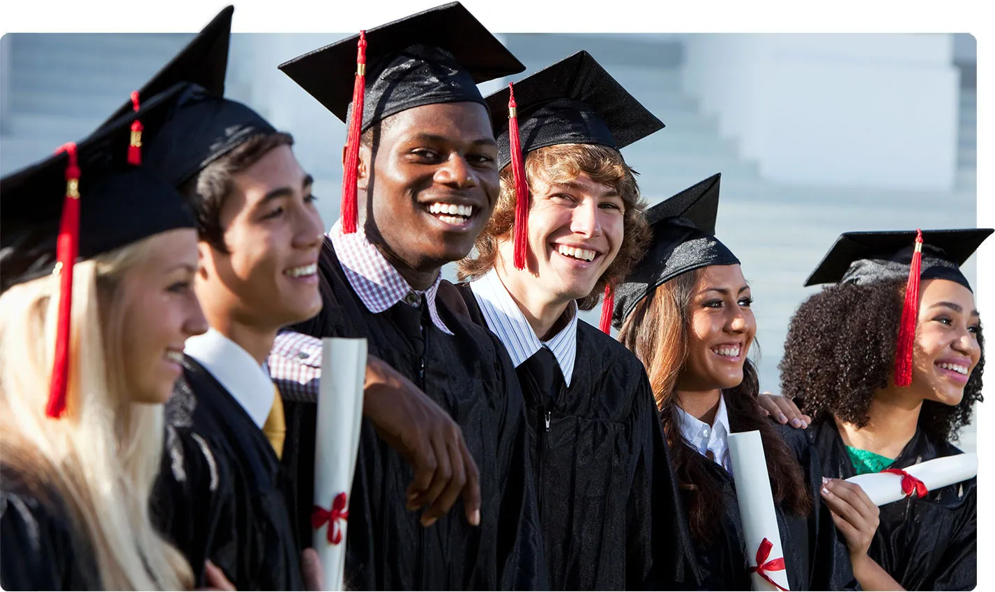 Smiling graduates with their diplomas.