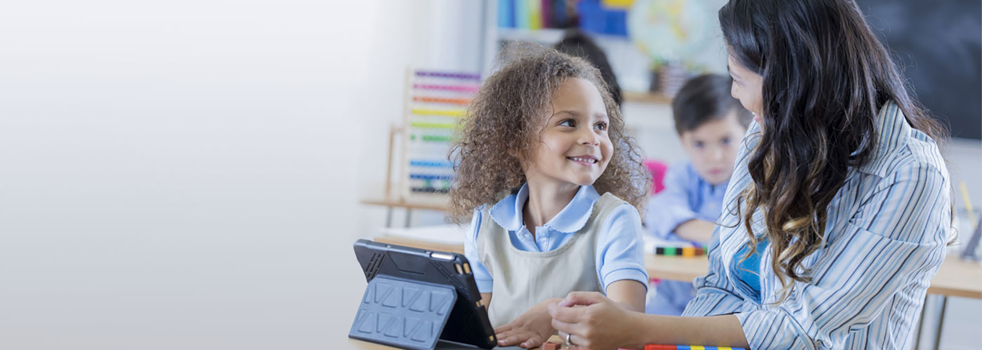 kids working with teacher on tablet