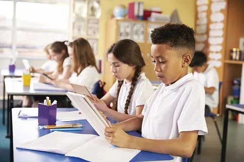 students looking over assignments at desk