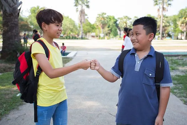 two students hand shaking outdoors