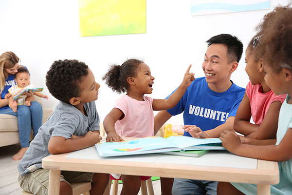 Young students with volunteer in classroom