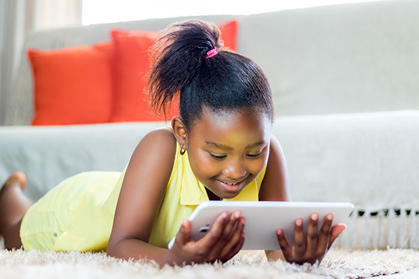 Little girl in yellow with a tablet