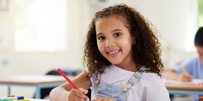 Smiling female student doing school work