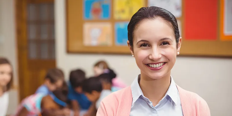 Smiling teacher in front of her classroom